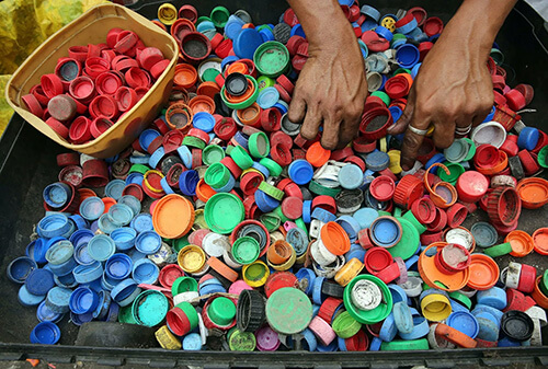 A pile of colorful plastic caps that represent the recycling process
